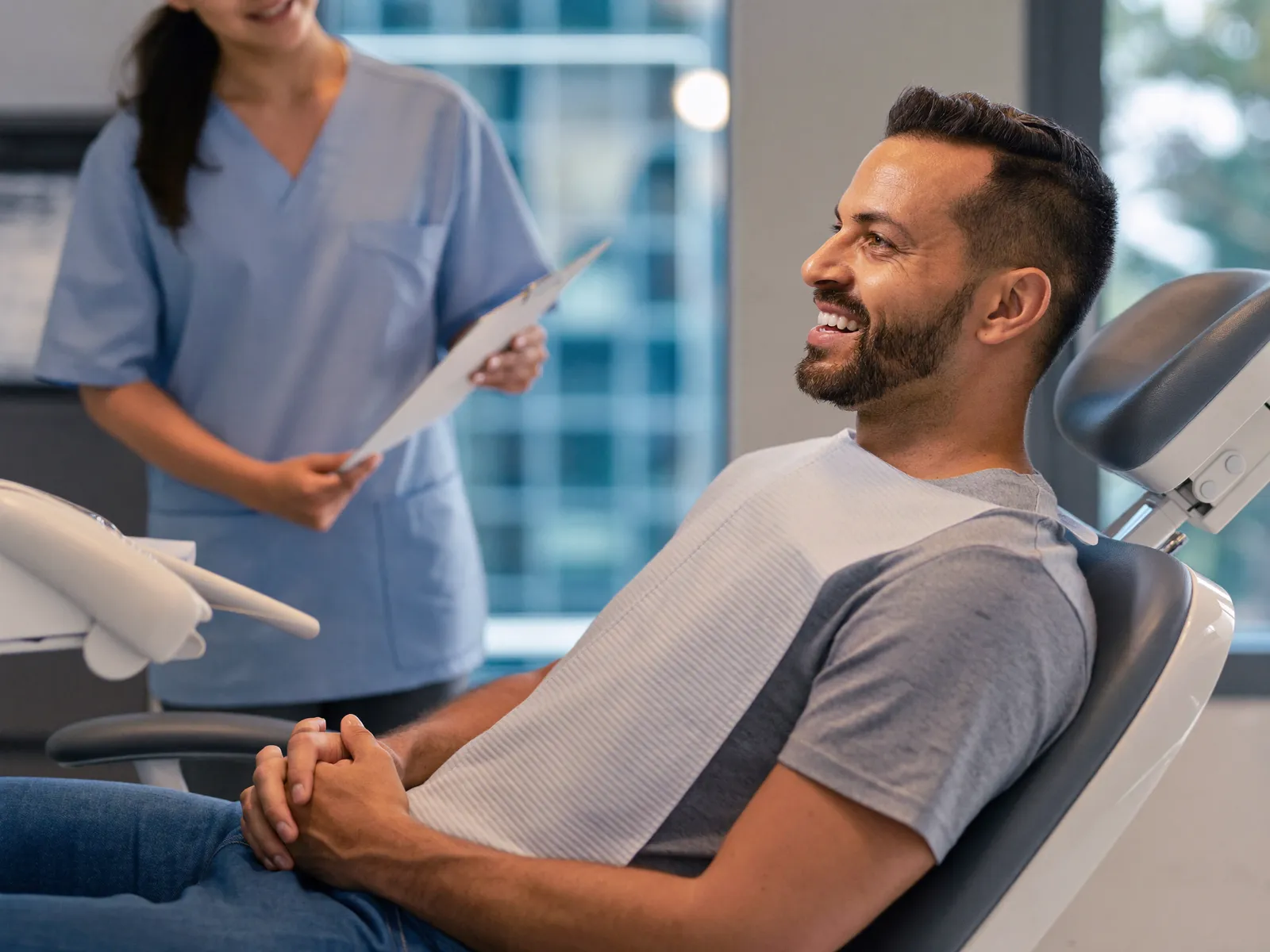 Un paciente sonriendo con su dentista durante un chequeo